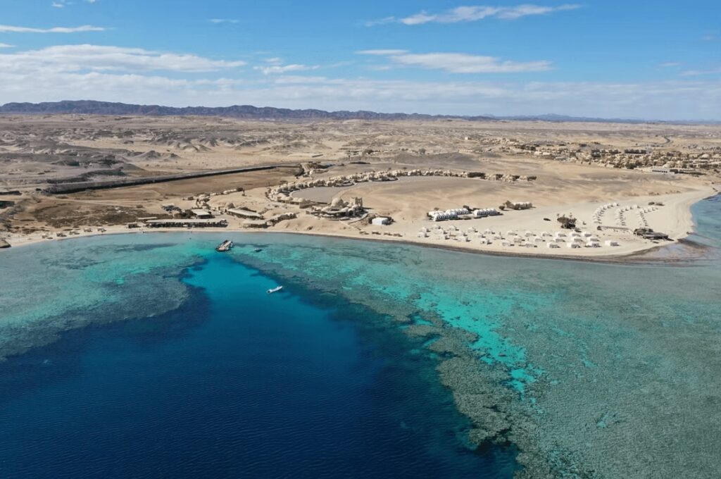 A Red Sea reefs meets the chalets and tents of Marsa Shagra Village, an eco-friendly dive resort in Marsa Alam