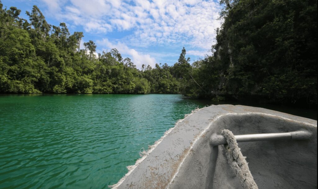 A boat cruises along a waterway near one of the best eco-dive resorts in Southeast Asia