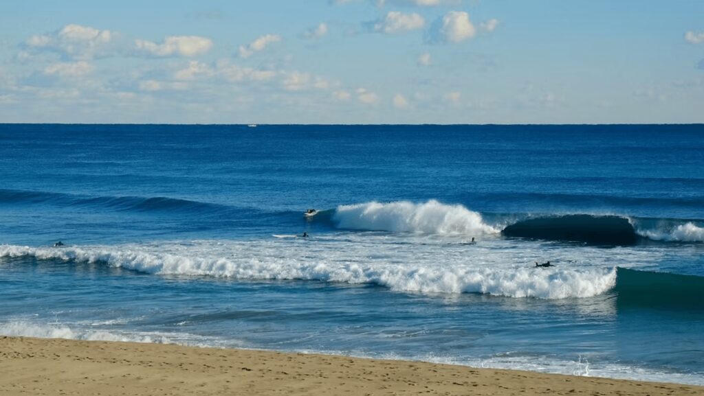 Best places to surf in Japan: Surfers riding a beach break in Japan