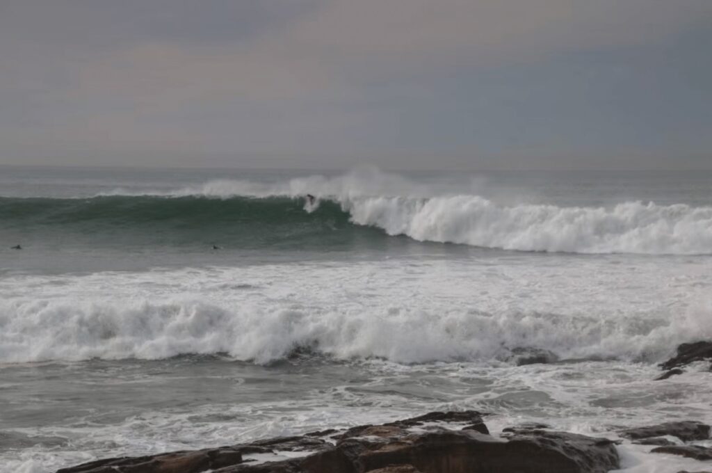 A surfer rides a wave at one of the best surf spots in Morocco