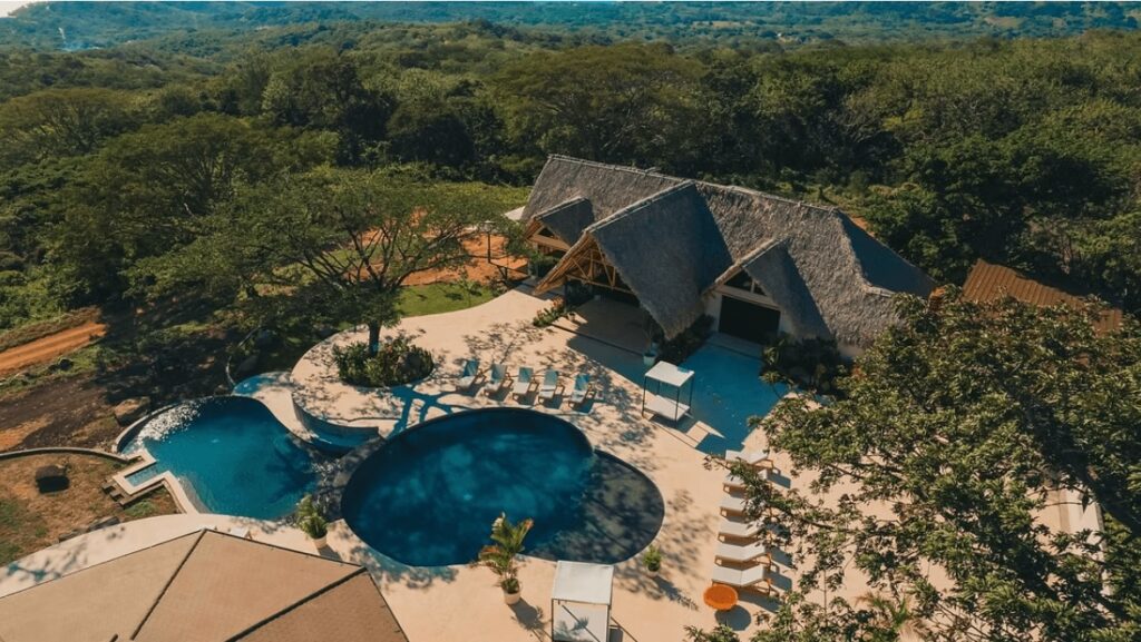 An aerial view of the main house and swimming pools at the TreeCasa Hotel & Resort, an eco-friendly hotel in San Juan del Sur