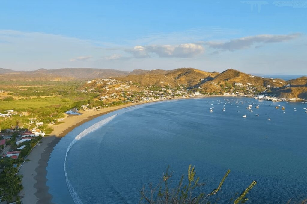 Best places to surf in Nicaragua: An elevated view of a curving beach in San Juan del Sur