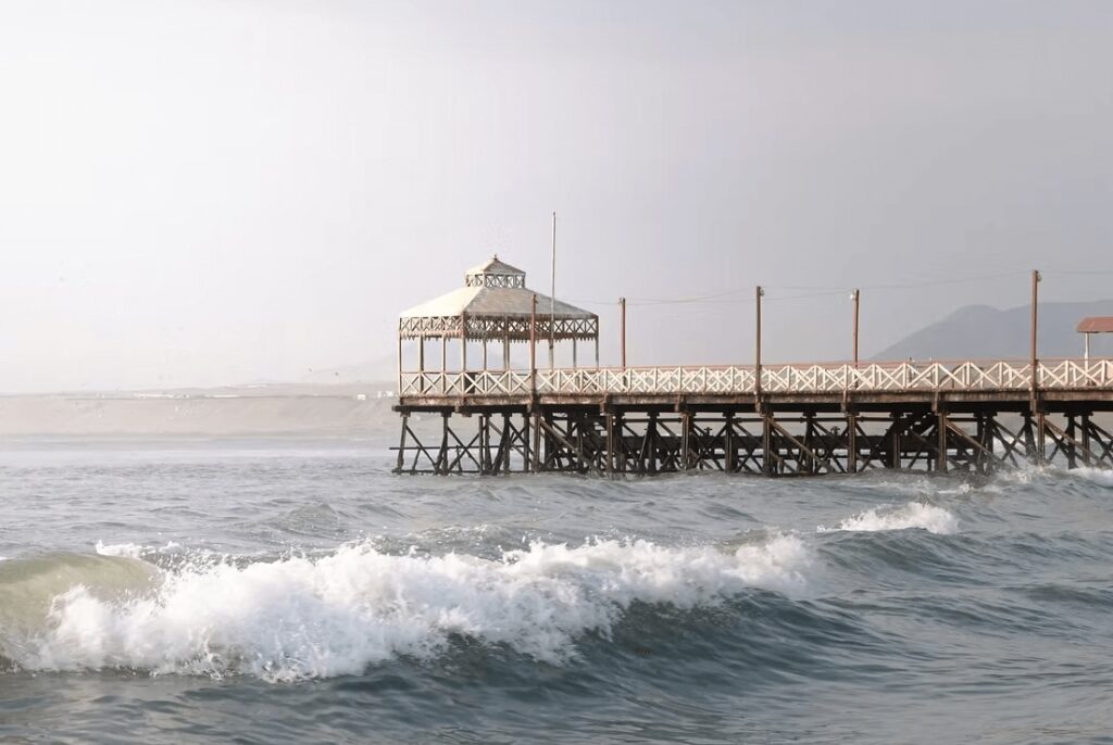 A pier stretches into the water at Huanchaco - one of the best places to surf in Peru