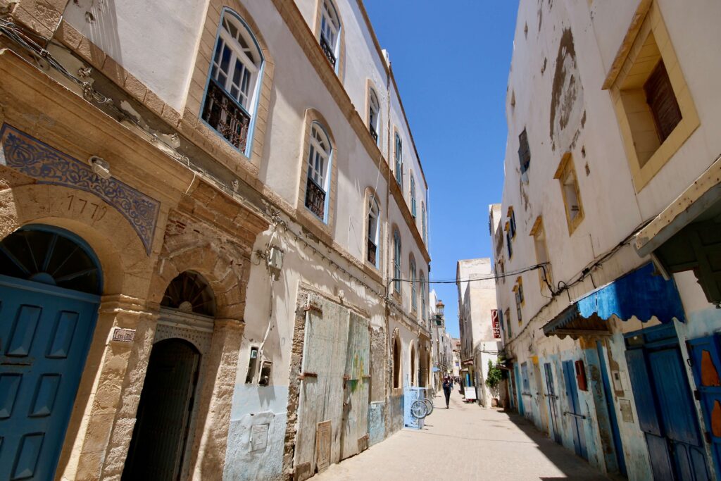 Blue and white buildings line a narrow street in the Essaouira medina