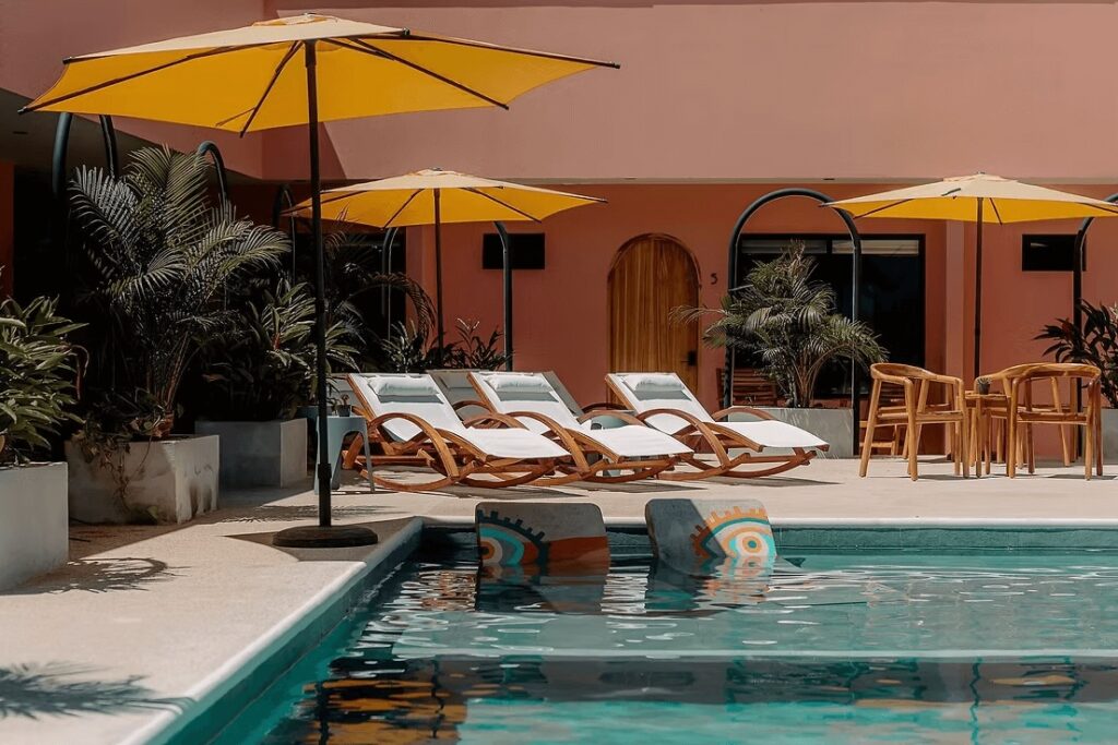 Sustainable hotels in Costa Rica for divers: Sun loungers beside a swimming pool at Hotel Amavi - one of the best places to stay while diving Tortuga Island