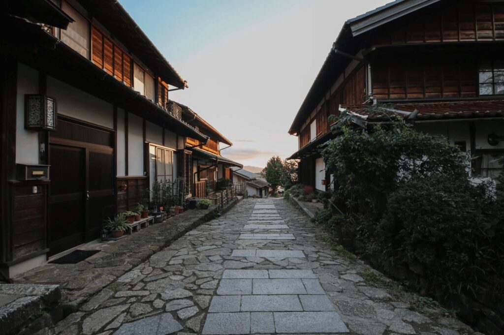 A stone pathway leads through a traditional town in Japan