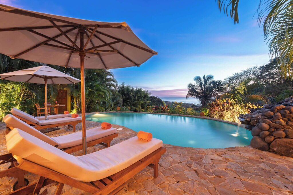 Sun loungers beside the swimming pool at Ocio Villas Mal Pais