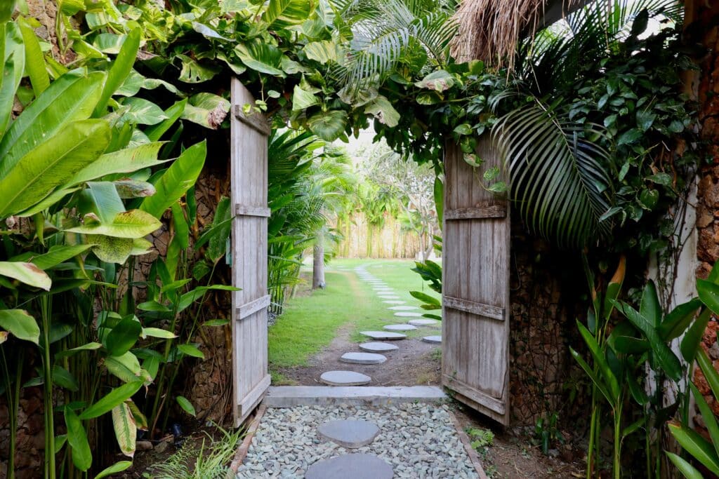 A stone path leads through a wooden gate in the grounds of Rascals in Kuta, Lombok
