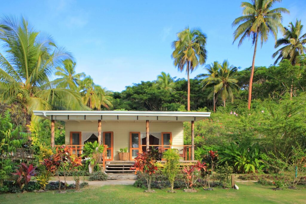 Palm trees tower above a cottage at the Sau Bay Resort & Spa in Fiji