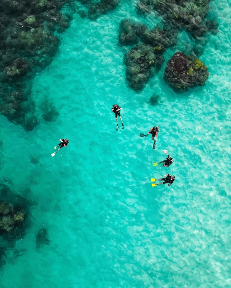 Divers floating at the ocean's surface during a scuba trip to the Coral Triangle