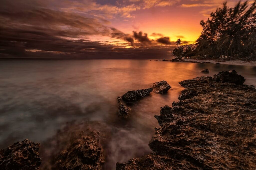 Scuba diving French Polynesia: Sunset illuminates a rocky coastline