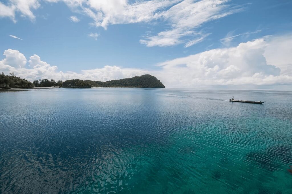 Best places to dive in Indonesia: A boat cruises between forested islands
