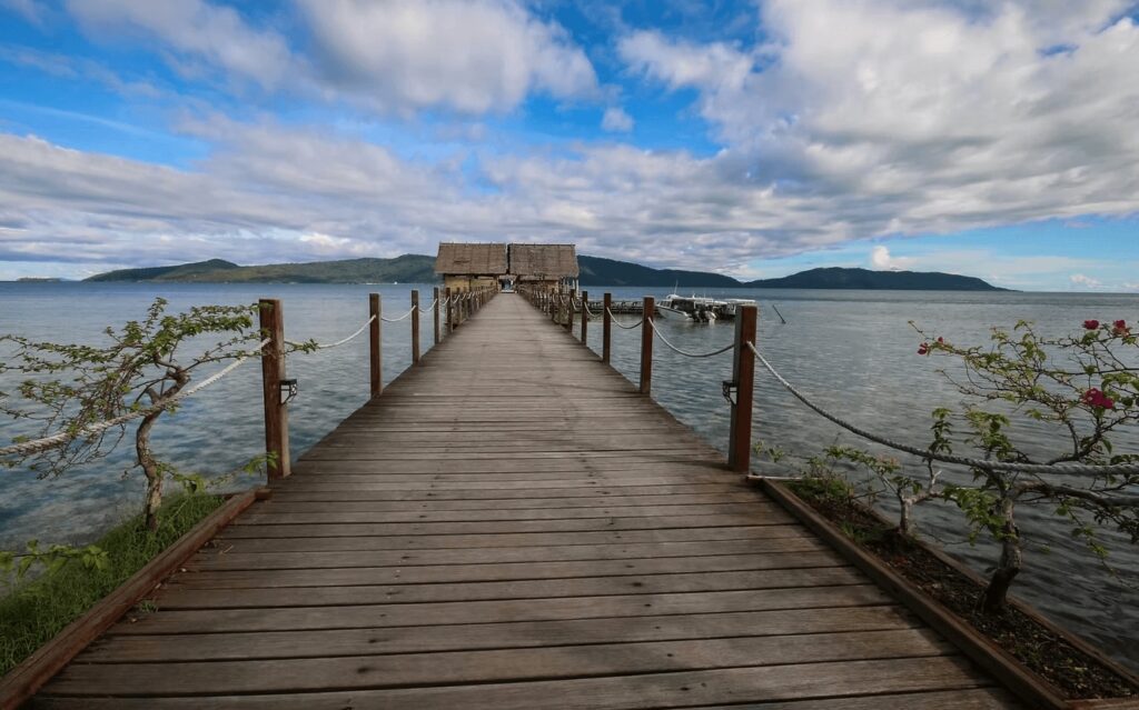 A jetty extends into the waters of Raja Ampat - one of the best places to dive in Indonesia