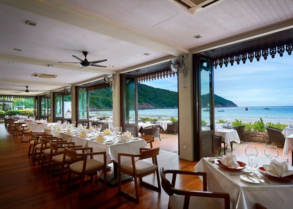 A waterfront restaurant at The Taaras Beach & Spa Resort, an eco-friendly hotel on Redang Island