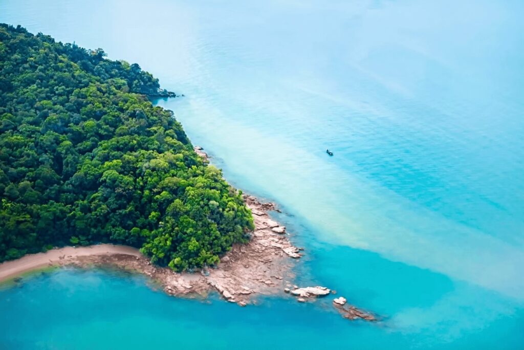Scuba diving in Malaysia: An elevated view of a rocky, forested coastline on the South China Sea