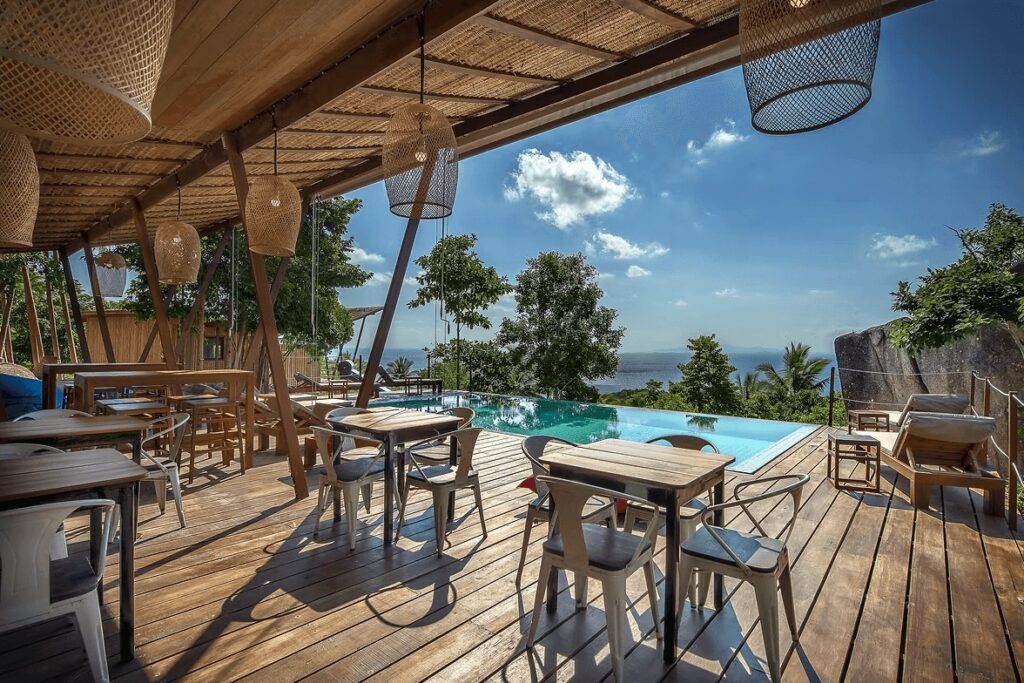 An open-air dining space overlooking the pool at Ecotao Lodge, a sustainable dive hotel in Koh Tao 