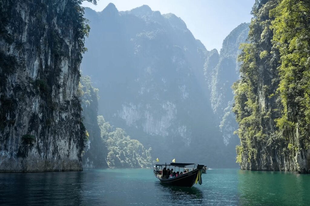 Scuba diving in Thailand: A wooden boat between towering limestone formations