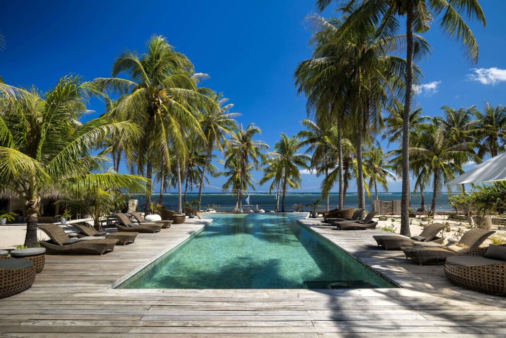 Sun loungers surround the swimming pool at Seed Resort on Rote Island