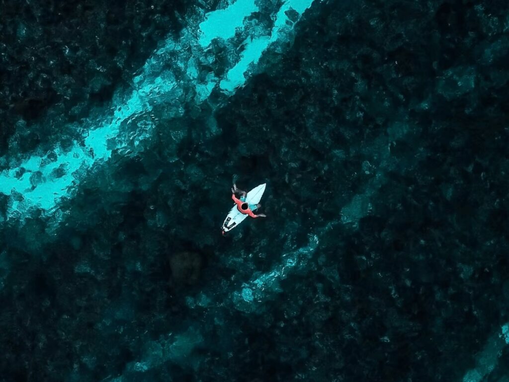 A bird's eye view of a surfer on a board at one of the best surf spots in Papua New Guinea