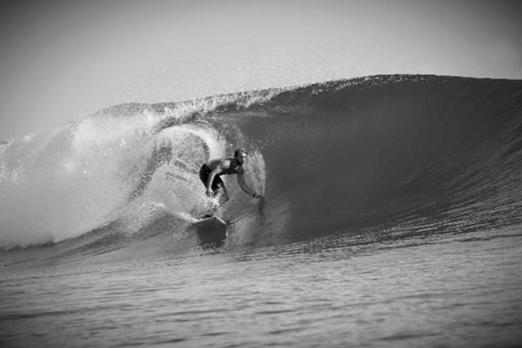 A surfer riding a wave at one of the best surf spots in Papua New Guinea