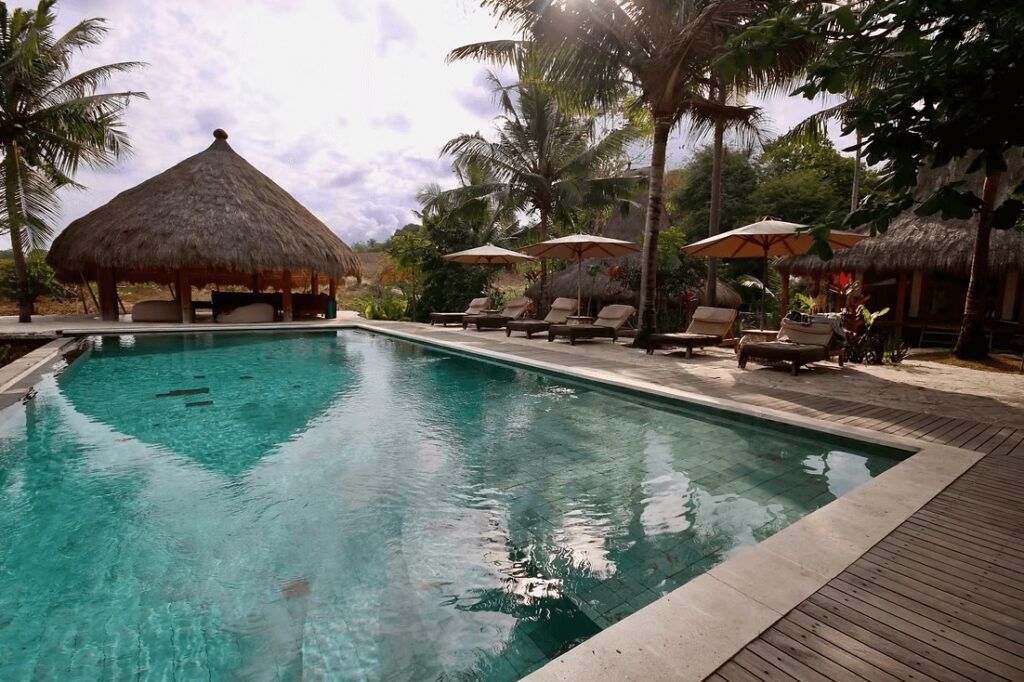 Sun loungers frame the sparkling swimming pool at Sumba Surf Camp