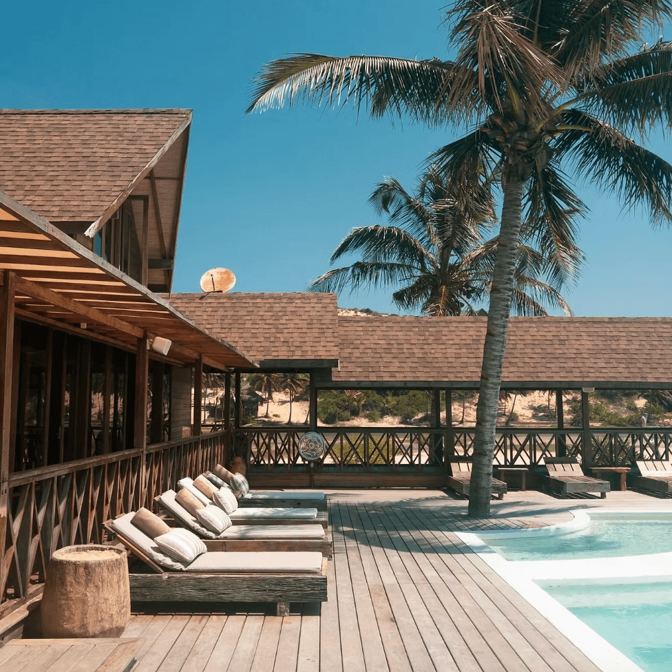 Sun loungers beside a pool at an eco-friendly resort in Mozambique for surfers