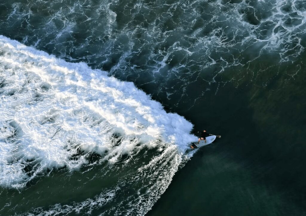 A bird's eye view of a paddle boarder surfing in Mozambique