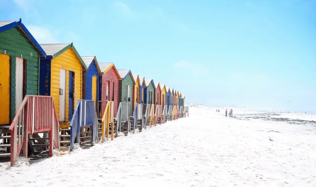 Surfing in South Africa: Colourful huts on a beach in Muizenberg