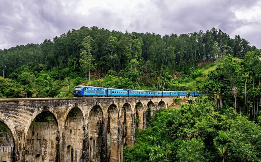Best surf spots in Sri Lanka: A blue train crosses a railway viaduct in Sri Lanka