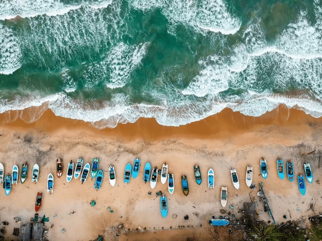 Surfing Sri Lanka: A bird's eye view of blue and white boats on a beach