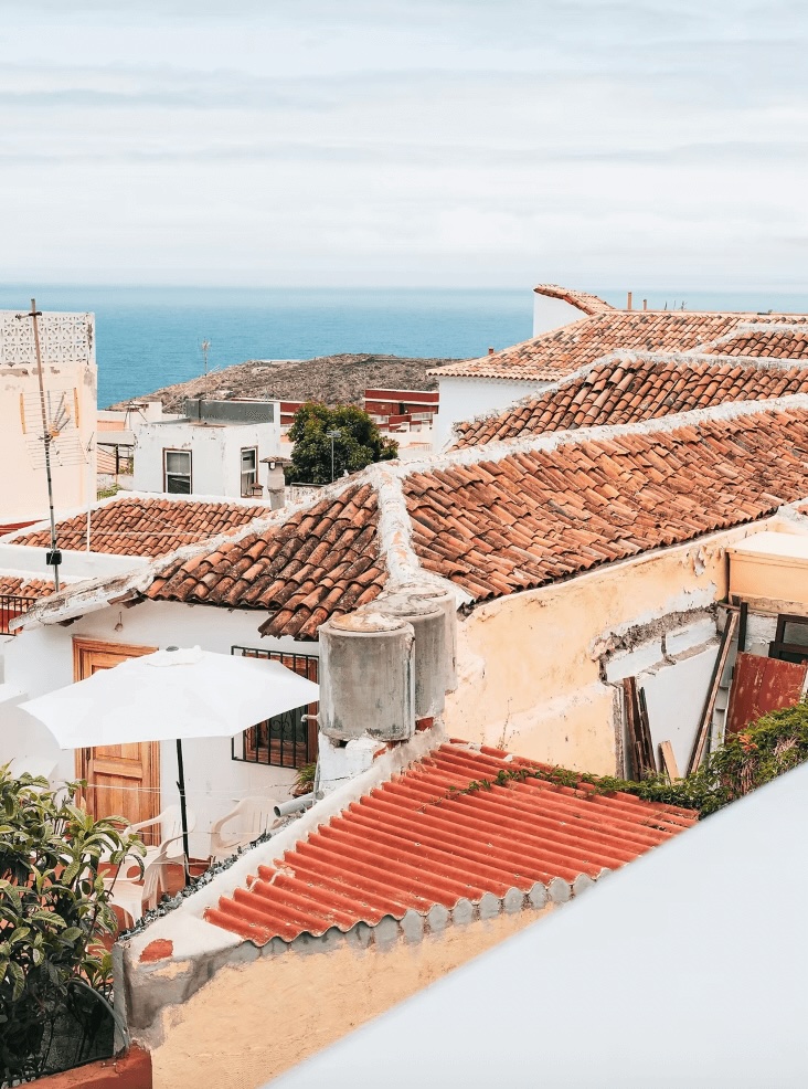 Surfing in the Canary Islands: Looking across a collection of red roofed buildings toward the Atlantic Ocean