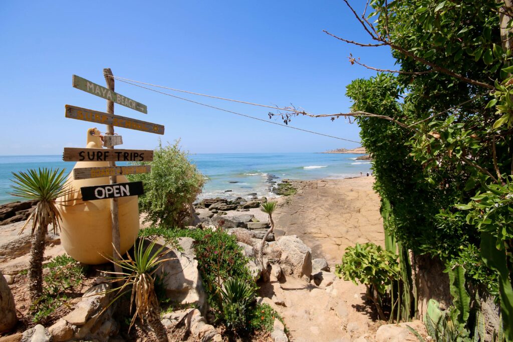 Best places to surf in Morocco: A wooden signpost on the coastline near Taghazout