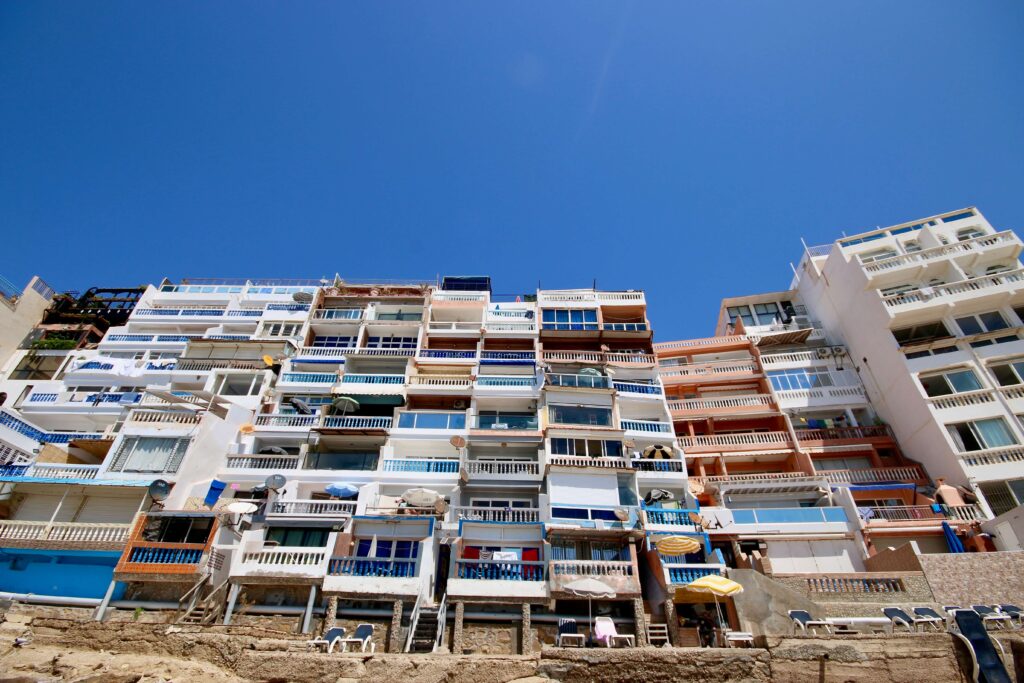 Best places to surf in Morocco: Colourful beach apartments overlook the coastline in Taghazout