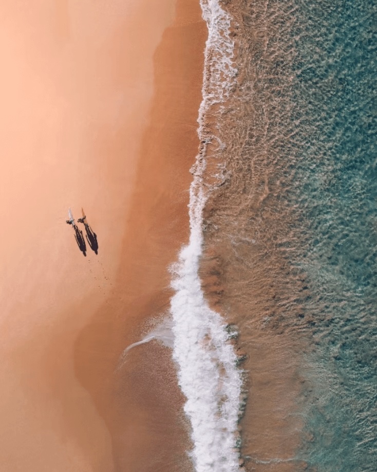 World Surfing Reserves: A bird's eye view of two surfers walking along a beach
