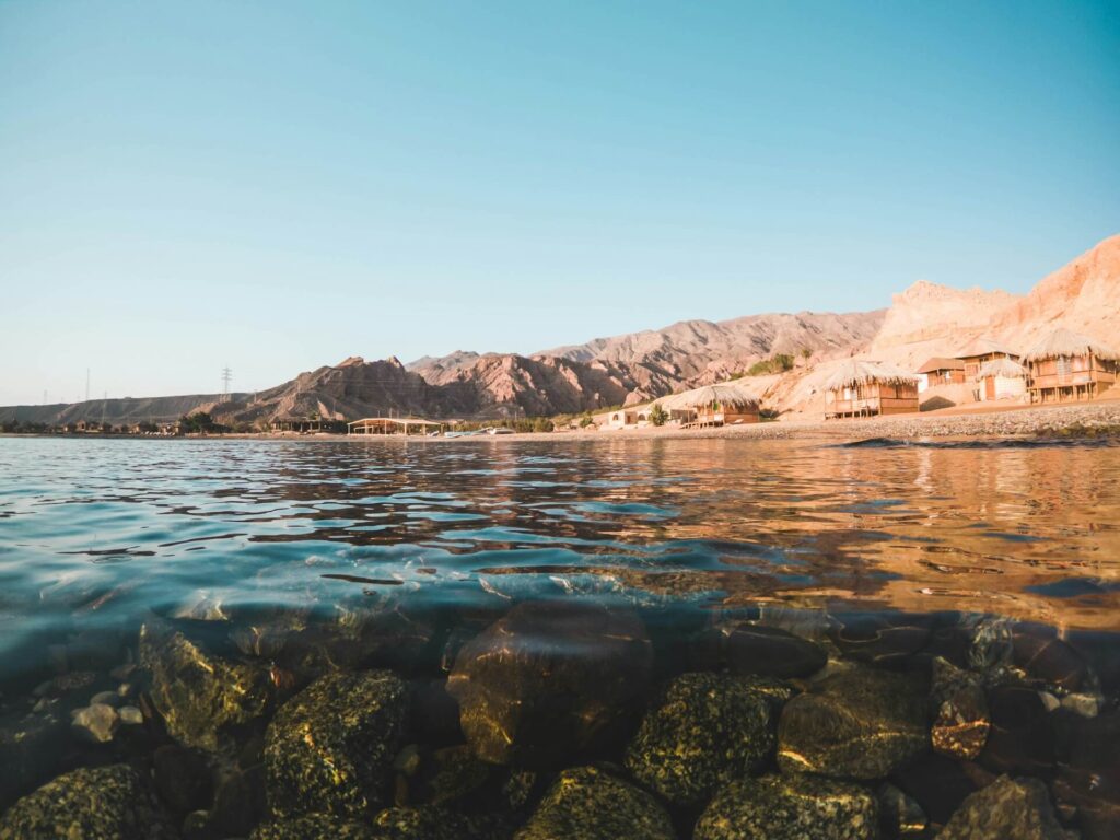 A rocky reef just below the water's surface along the Red Sea coastline