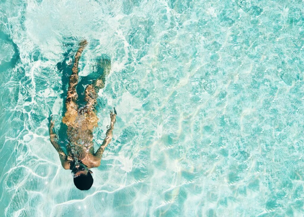 A swimmer in clear, shallow water