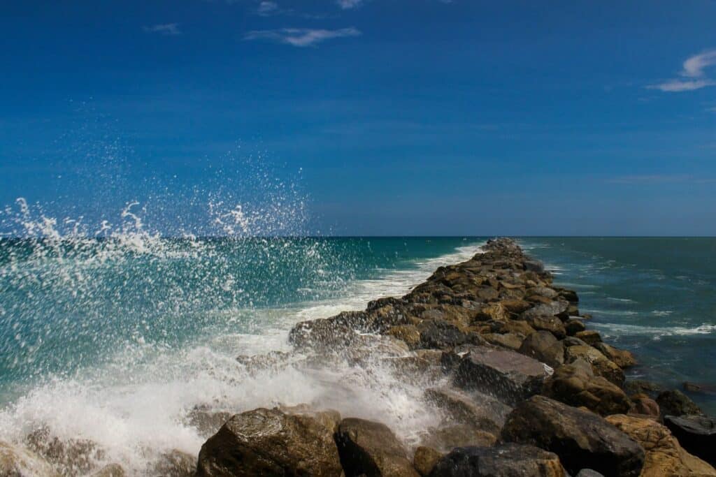 Coastal breakwaters and sea walls can alter natural sand movement and wave refraction