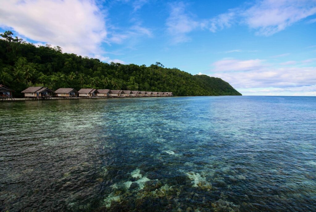 Overwater bungalows at a regenerative tourism resort in Raja Ampat